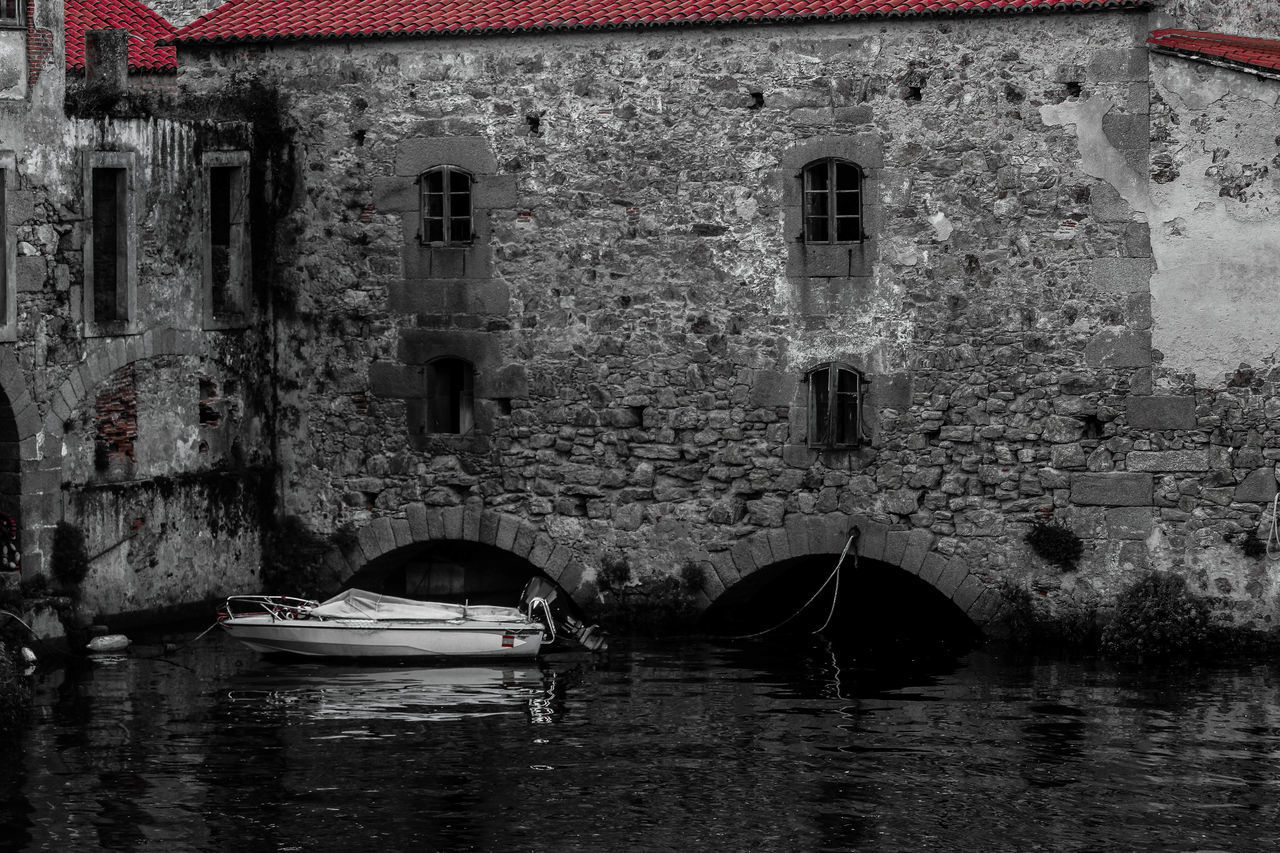 BOAT IN CANAL ALONG BUILT STRUCTURES