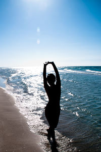 Full length of silhouette woman walking at beach against sky