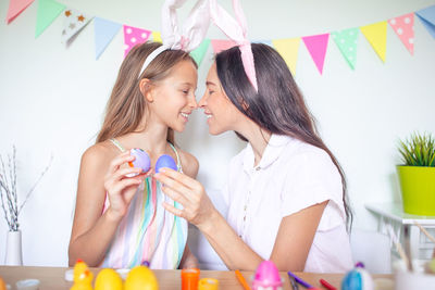 Mother and girl wearing hat on table