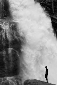 Full length of man standing by waterfall