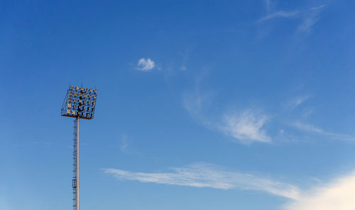 Low angle view of floodlight against blue sky