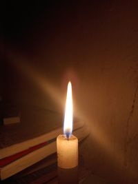 Close-up of lit candle in darkroom