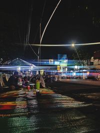 People on illuminated street at night