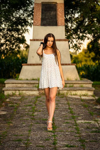 Portrait of young woman standing against waterfall