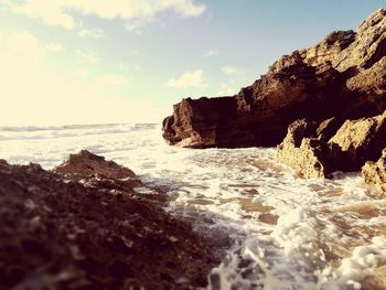 Rock formations by sea against sky