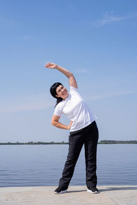 Full length of man standing by sea against sky