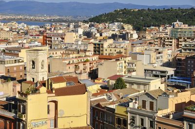 Aerial view of city by sea against sky