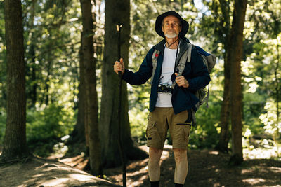 Portrait of young man standing in forest