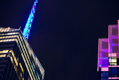 Low angle view of illuminated skyscraper against sky at night