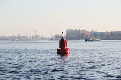 Red ship in sea against clear sky