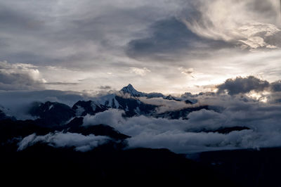 Snow capped peak of sacred mountain kawagarbo emerges from majestic sky from a distance