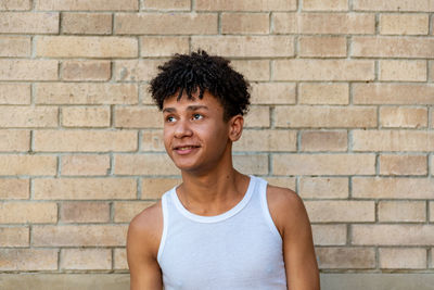 Portrait of teenage girl against brick wall