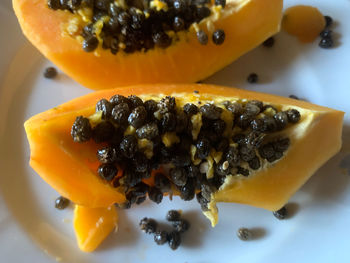 Close-up of papaya fruit with kernels served on plate