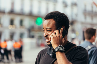 Portrait of young man using mobile phone in city