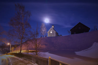 Illuminated cross against sky at night during winter