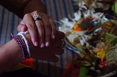 Cropped image of bride and bridegroom holding hands during wedding ceremony