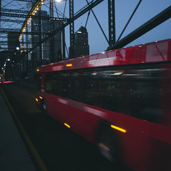 Blurred motion of train on illuminated city against sky at night