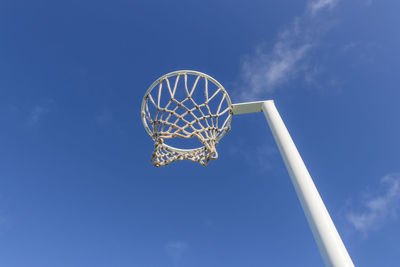 Low angle view of basketball hoop against blue sky