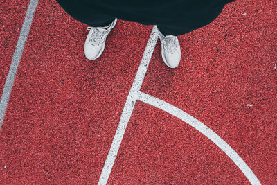 Low section of person standing on red floor