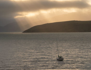 Solitary boat floating on the water during sunrise, christchurch, new zealand