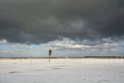 View of beach against cloudy sky