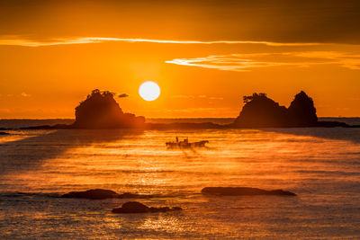 Scenic view of sea against orange sky