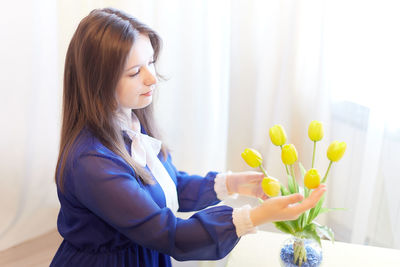 Portrait of young woman holding flowers