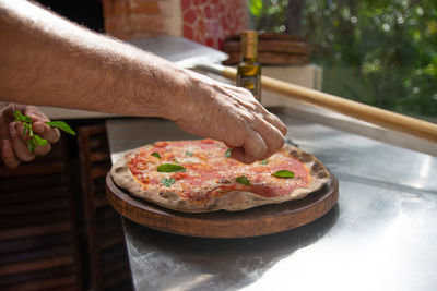 Cropped hand of man holding pizza