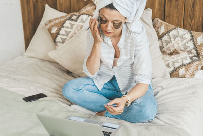 Woman at home on bed makes purchases on the internet. the joy of the black friday sale.