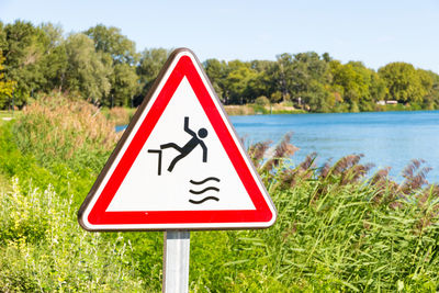 Close-up of road sign by lake