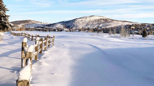 Panoramic view of frozen lake by snowcapped mountain against sky