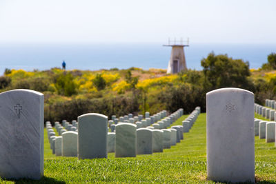 Tombstones in cemetery against sky