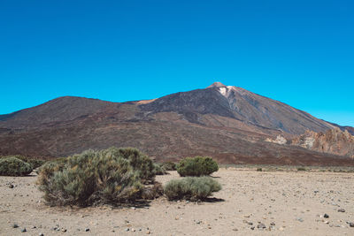 Scenic view of mountains against clear blue sky