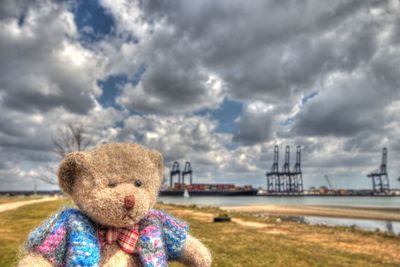 Close-up of stuffed toy on land against sky