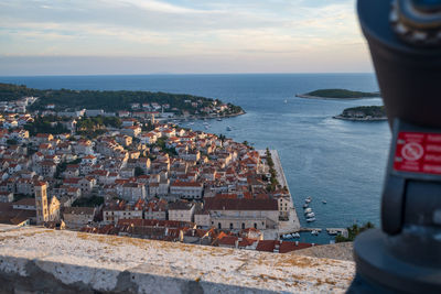 High angle view of townscape by sea against sky during sunset