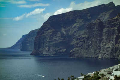 Scenic view of calm sea against rocky mountains