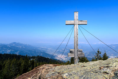 Windmill on mountain against clear blue sky