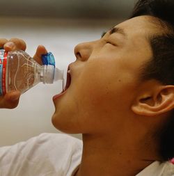 Close-up of man drinking water from bottle