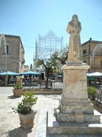 Statue against buildings in city