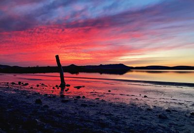 Scenic view of sea against cloudy sky during sunset