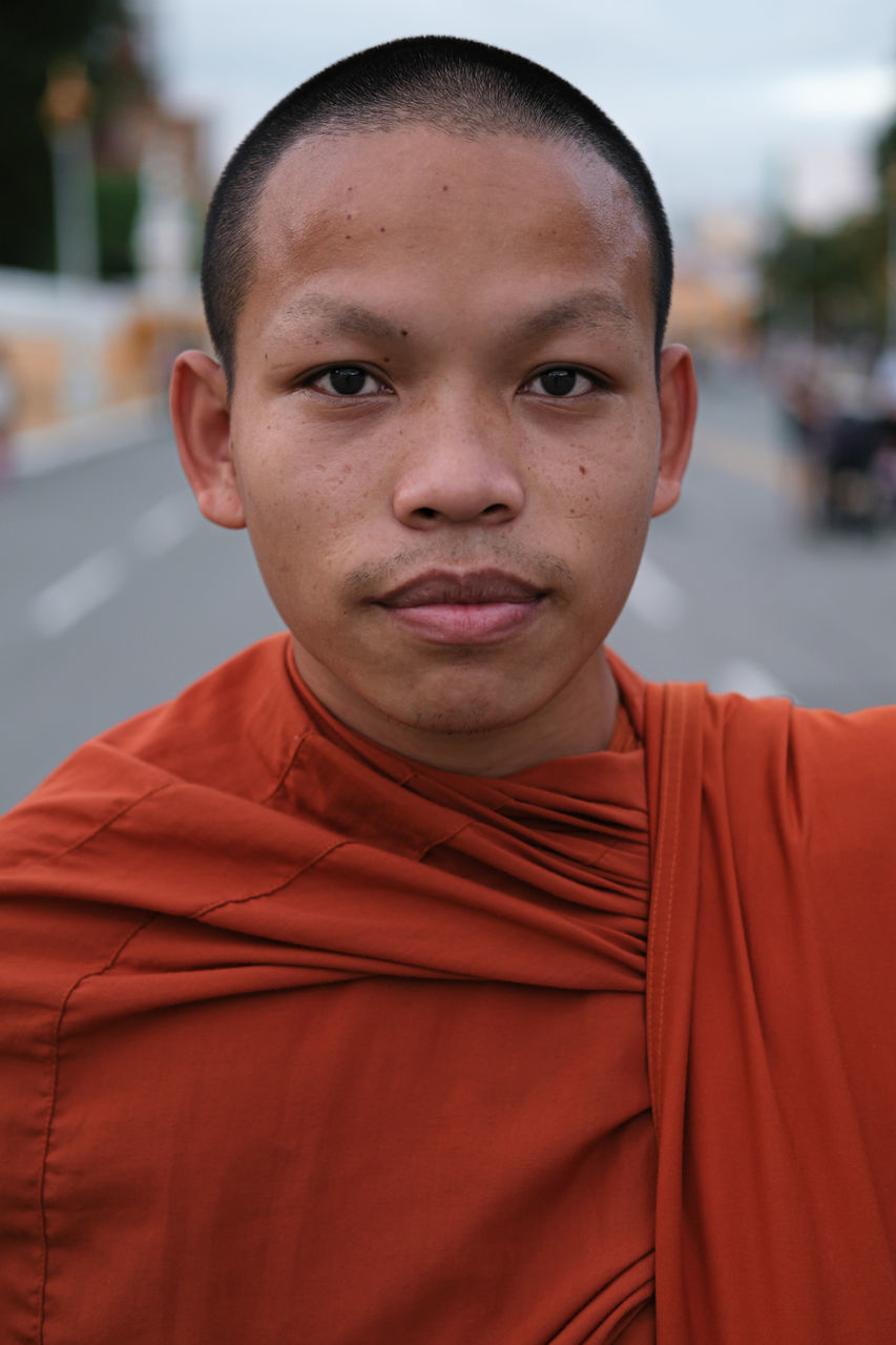 Young Monk near the Royal Palace, Phnom Penh - Cambodia Streetportrait Streetphotography Monk  ASIA Cambodia Orange Color Orange Spirituality Portrait Looking At Camera Shaved Head Headshot Men Human Face Close-up