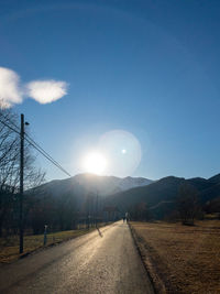 Road amidst trees against sky