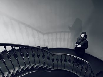 High angle view of woman standing on staircase at home