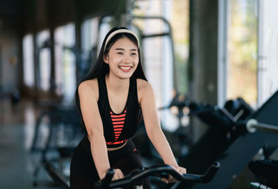 Portrait of young woman exercising in gym