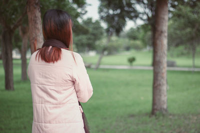 Rear view of woman standing on field