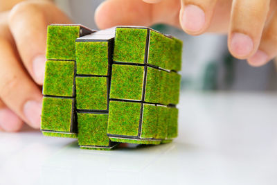 Close-up of person touching cube on table