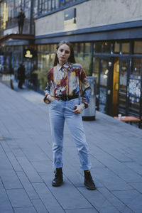 Portrait of young woman standing in city