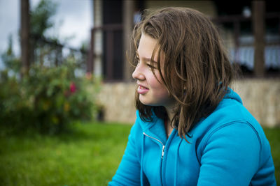 Close-up of teenage girl sitting on field