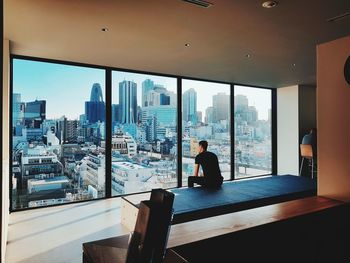 Woman sitting by window in modern building