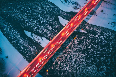 Aerial view of illuminated bridge over river in city at night